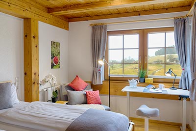 Schlafzimmer mit Doppelbett und Arbeitsbereich