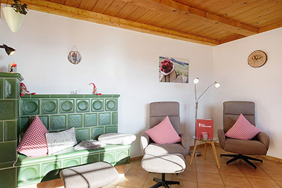 Wohnbereich mit Sesseln und Kachelofen